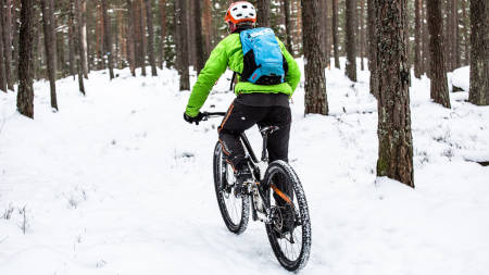 SKOGENS RO: Aslak Mørstad er en ivrig vintersyklist, men passer på å ikke fryse. Med seg i sekken har han for eksempel alltid med seg en god og varm dunjakke. Foto: Christian Nerdrum